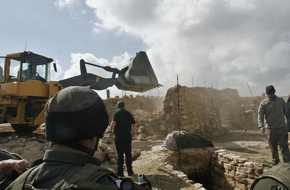 Border Police officers restraining a Bedouin man while his house is destroyed south of the West Bank city of Hebron on Wednesday Feb 14, 2007. 